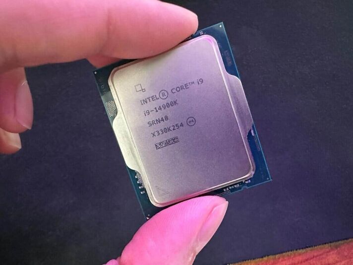 The Intel Core i9 14900K being held up in a review.