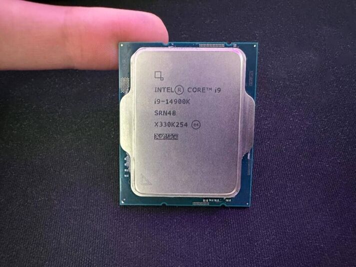 An intel Core i9 CPU is being held up by a person during the 14900K review.